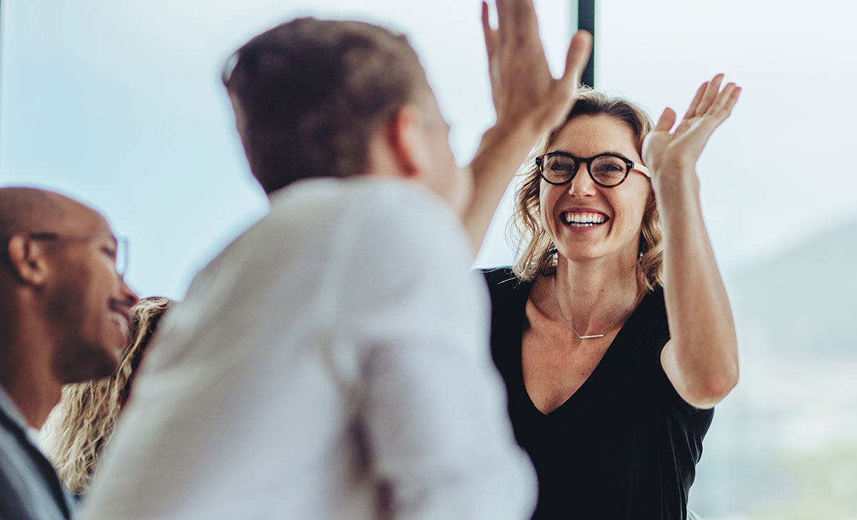 Ein Mann und eine Frau klatschen sich ab, geben sich high five.